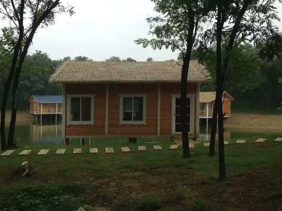 Lakeside Small Wooden Houses Offer Serene Nature Escape with Thatched Charm